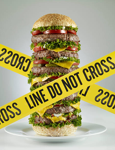 Diet Zone Huge hamburger with yellow cordon tape. big plate of food stock pictures, royalty-free photos & images