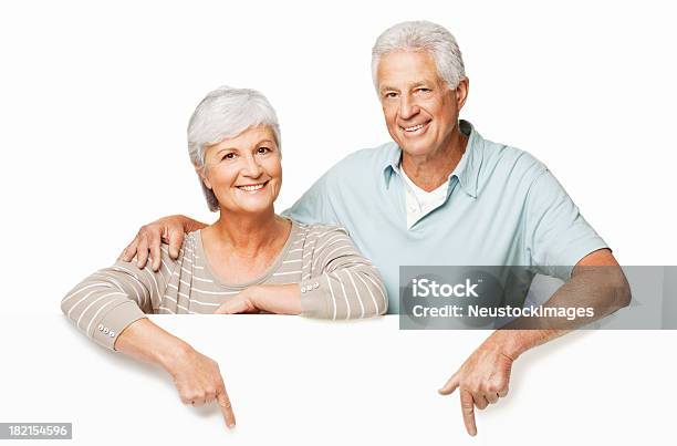 Senior Couple Pointing Over A Wall Isolated Stock Photo - Download Image Now - Pointing, Cut Out, Senior Adult