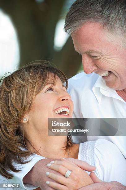 Mature Couple Cuddling And Laughing Stock Photo - Download Image Now - 50-59 Years, 60-69 Years, Active Seniors