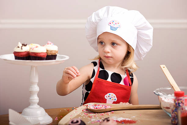 istock Cupcake Decorating by Little Girl in Chef's Hat and Apron 182155322