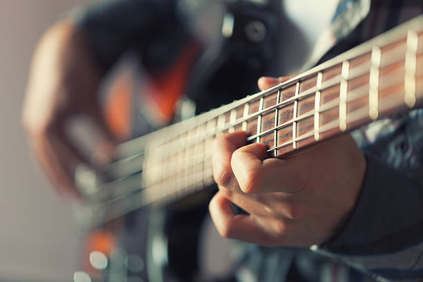 Playing Guitar Musician playing guitar. bass guitar stock pictures, royalty-free photos & images