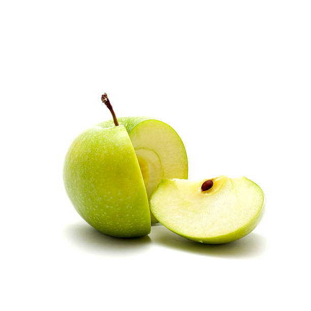close up shot of green sliced apple close up shot of green bright apple. green apple slice stock pictures, royalty-free photos & images