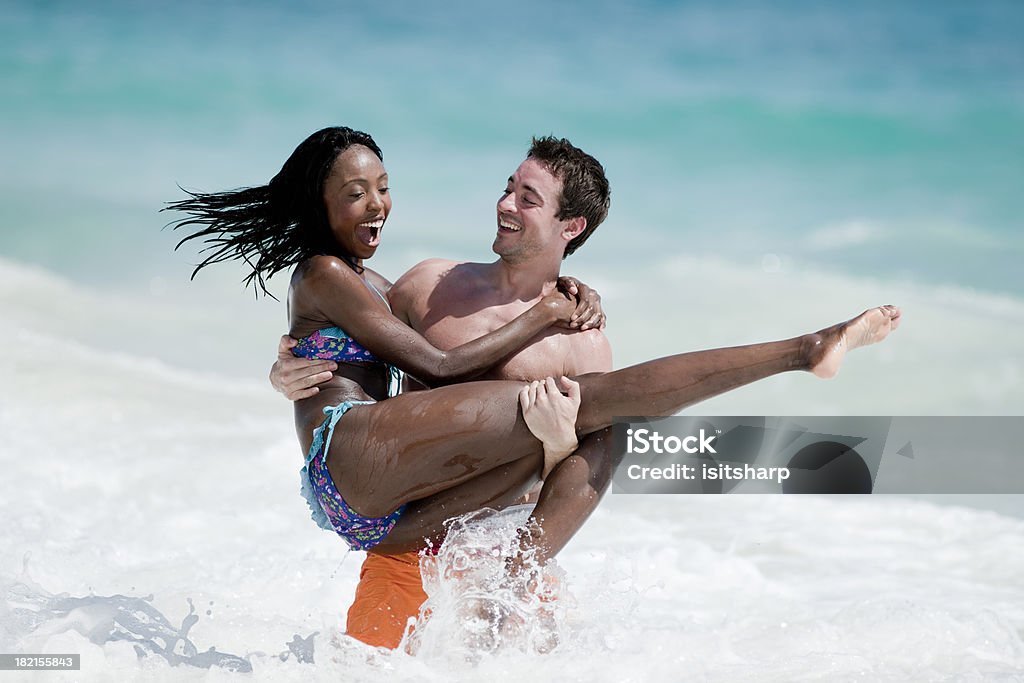 Young Couple "Young couple playing together in the sea and surf, backlit" Beach Stock Photo