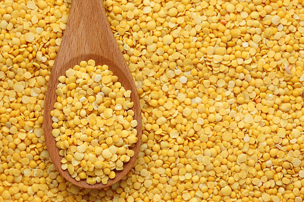istock Yellow lentils in a wooden spoon 182156120