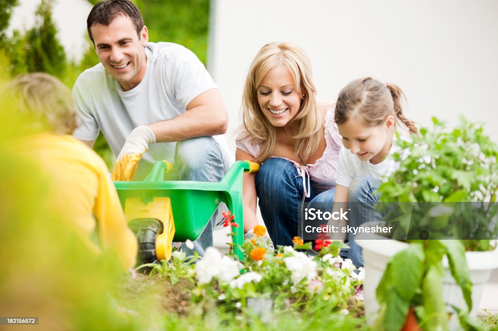 Happy family Plantando flores. - Foto de stock de Jardinería libre de derechos