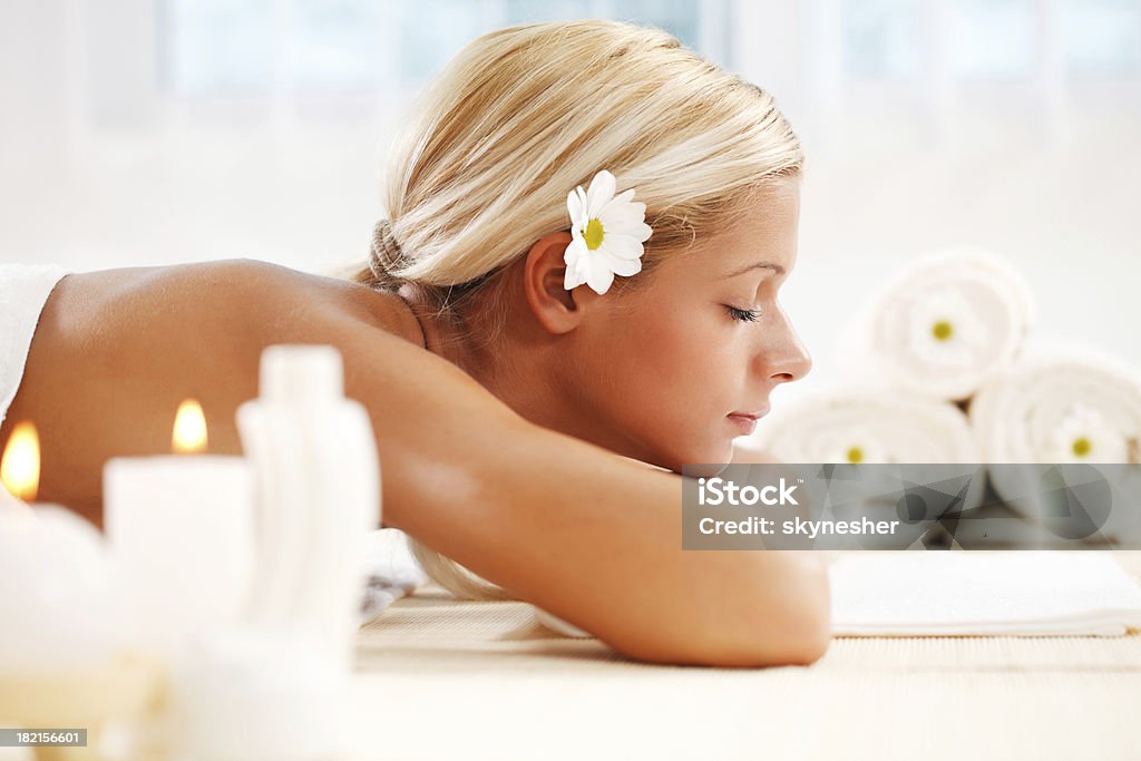 Piękna młoda kobieta o blond włosach bawi się w centrum spa - Zbiór zdjęć royalty-free (Białe tło)