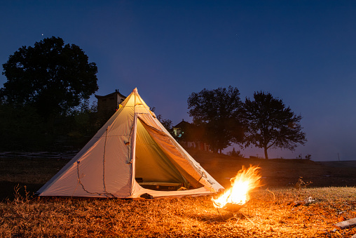 Pyramid tent and bonfire at night