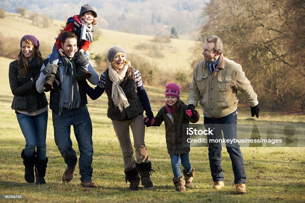 Tre generazione famiglia in piedi nella campagna in inverno - Foto stock royalty-free di Inverno