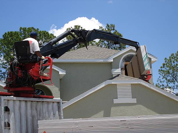 istock Man using lift to hand sheet rock through opening. 182157076