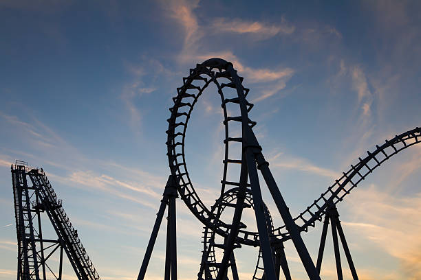 Silhouetted Roller Coaster Loops at Sunset stock photo