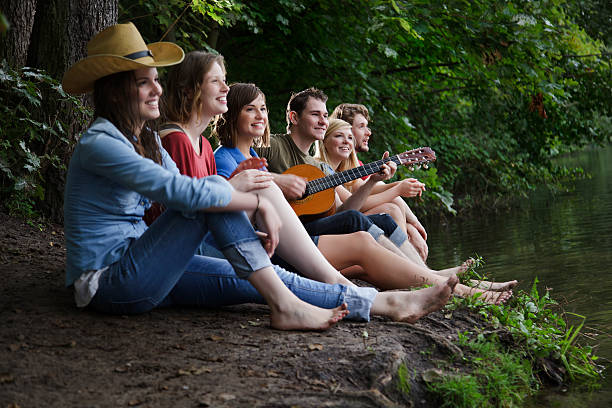 istock Friends on a Camping Trip Singing and Playing Guitar 182157267