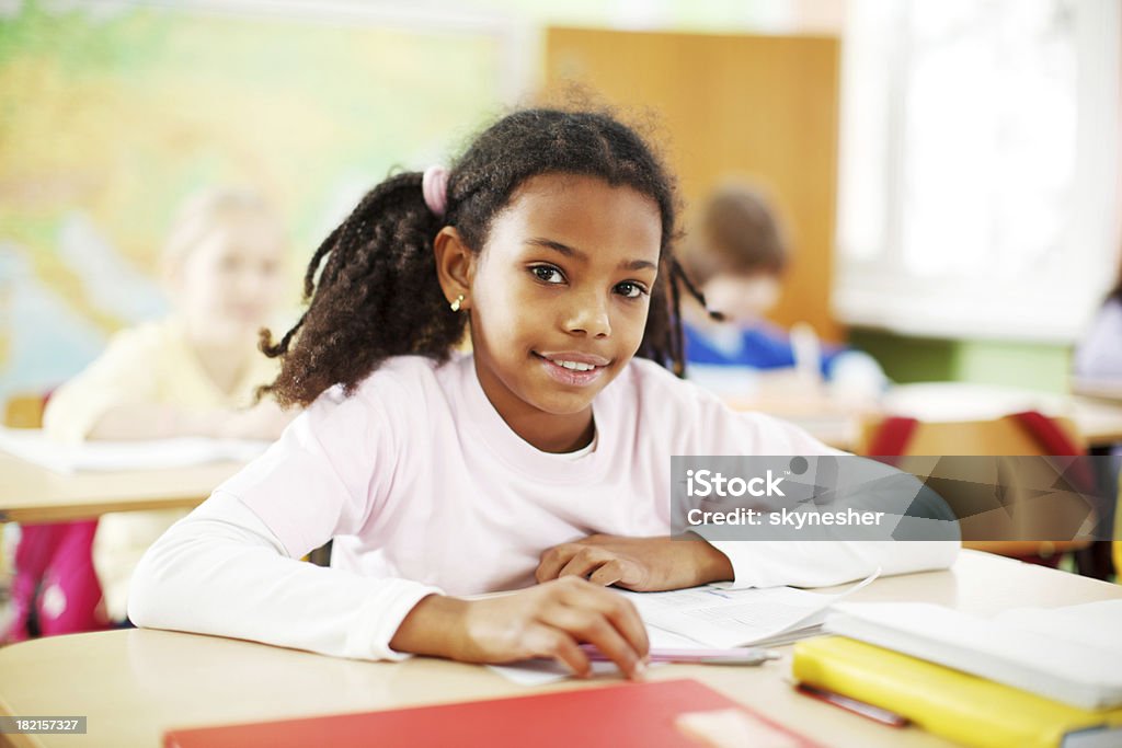 Ładny African-American dziewczyna jest nauki w klasie. - Zbiór zdjęć royalty-free (Afroamerykanin)