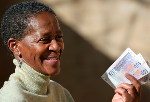 An ethnic african lady holding a fistfull of bank notes. Canon 350D. July 2006.