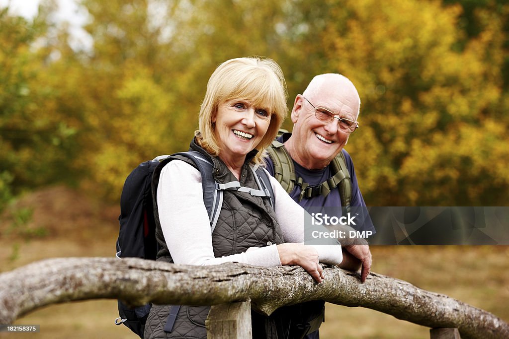 Happy senior hikers de pie junto a la valla - Foto de stock de Actividad al aire libre libre de derechos