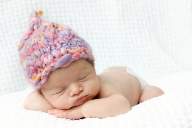 istock Newborn baby asleep with pink hand knit hat 182158539