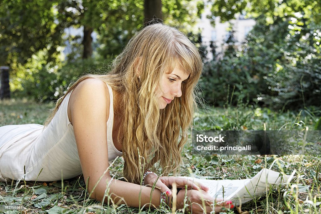 Jeune femme lisant dans le parc - Photo de Femmes libre de droits