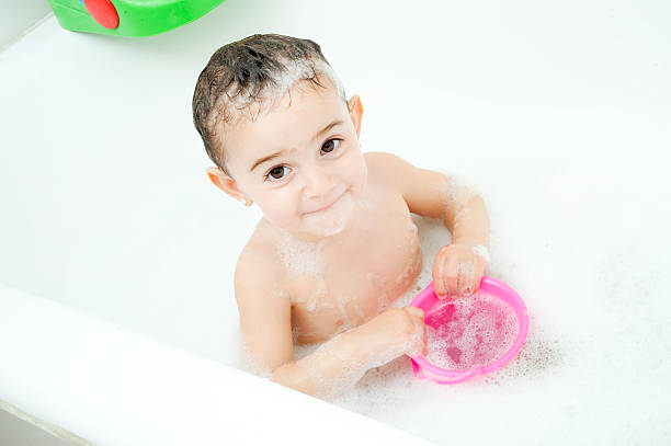 Baby girl taking a bath. stock photo