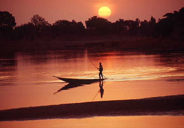 Boat on the Bani river in Mali during sunrise "Boat on the Bani river in Mali during sunrise near Djenne," Mali stock pictures, royalty-free photos & images