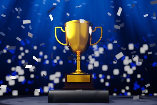 Close-up of a long row of trophies. Shot with shallow depth of field.  All the trophies are the same. A cool cyan color scheme dominates the scene.