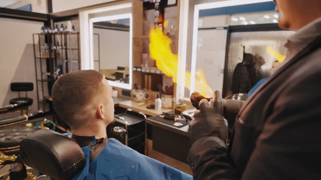 Professional Barber Using Burning Fire Treatment Finishing Haircut and Styling for his Client in Salon