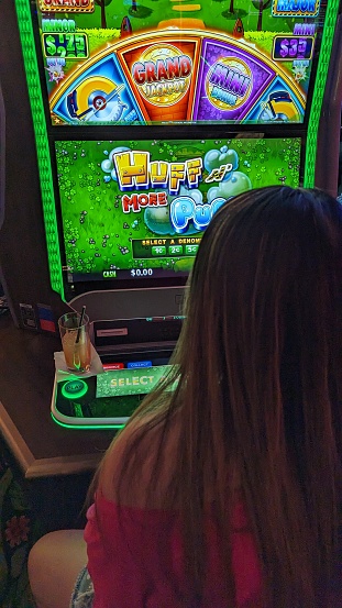 A young woman playing on a slot machine in Las Vegas Nevada USA April 2023