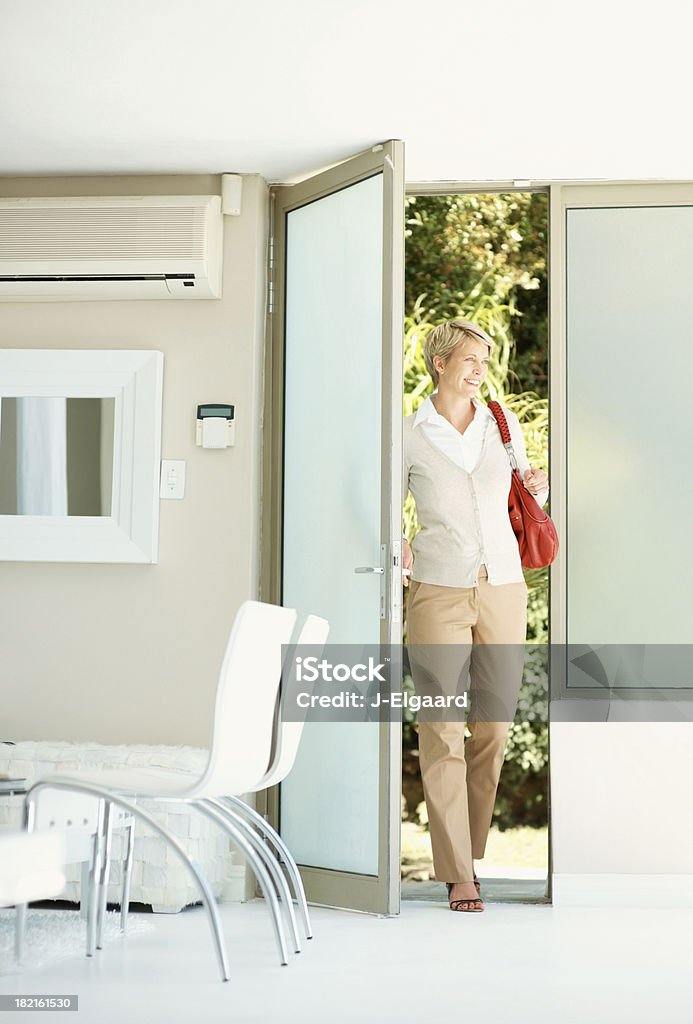 Женщина, введя свой дом в дверь - Стоковые фото Ходьба роялти-фри