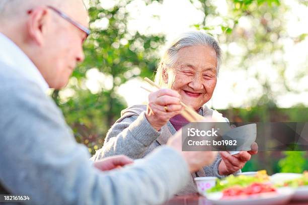 Feliz Comida En El Jardín Foto de stock y más banco de imágenes de Tercera edad - Tercera edad, Comer, Etnias asiáticas e indias