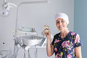 Female dentist with plastic denture model