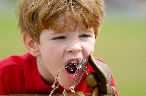 Little girl drinking from a water fountain