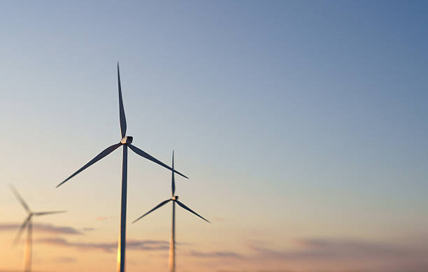 Trois Éoliennes au coucher du soleil. - Photo