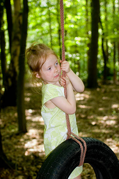 pequena menina loira, uma corda de escalada na floresta - little girls fun lifestyle handcarves imagens e fotografias de stock
