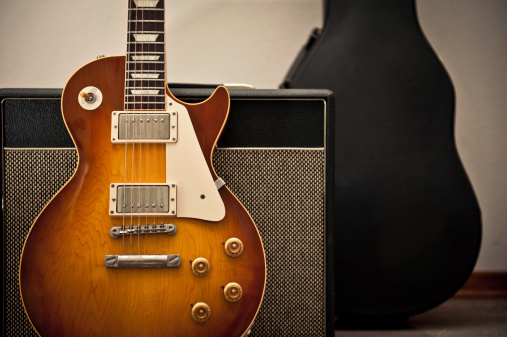 Red electric guitar and classic amplifier. Musical instrument guitar. Close-up.