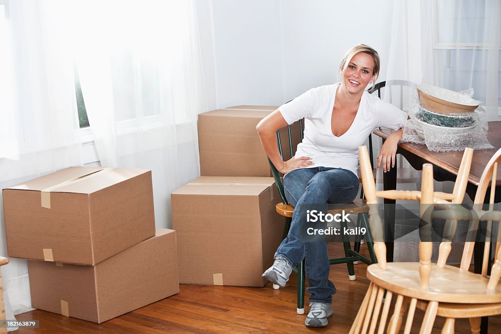 Young woman moving into new home Woman, 20s, moving house -taking a break from packing or unpacking boxes. 20-24 Years Stock Photo