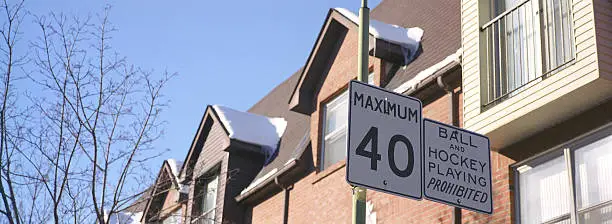road side sign for speed limit and row of town houses in the background