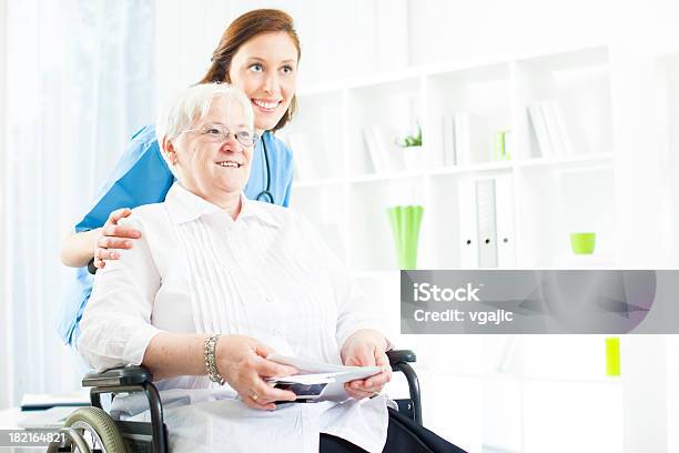 Senior Mujer En Un Asilo De Ancianos Foto de stock y más banco de imágenes de Ayudante - Ayudante, Silla de ruedas, Cuidador en el hogar