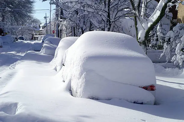 Parked cars covered with snow after blizzard in the city.  
