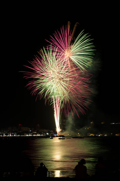 海辺の人々と街の常夜灯の背景とカラフルな花火のお祝い。 - fire firework display new year ストックフォトと画像