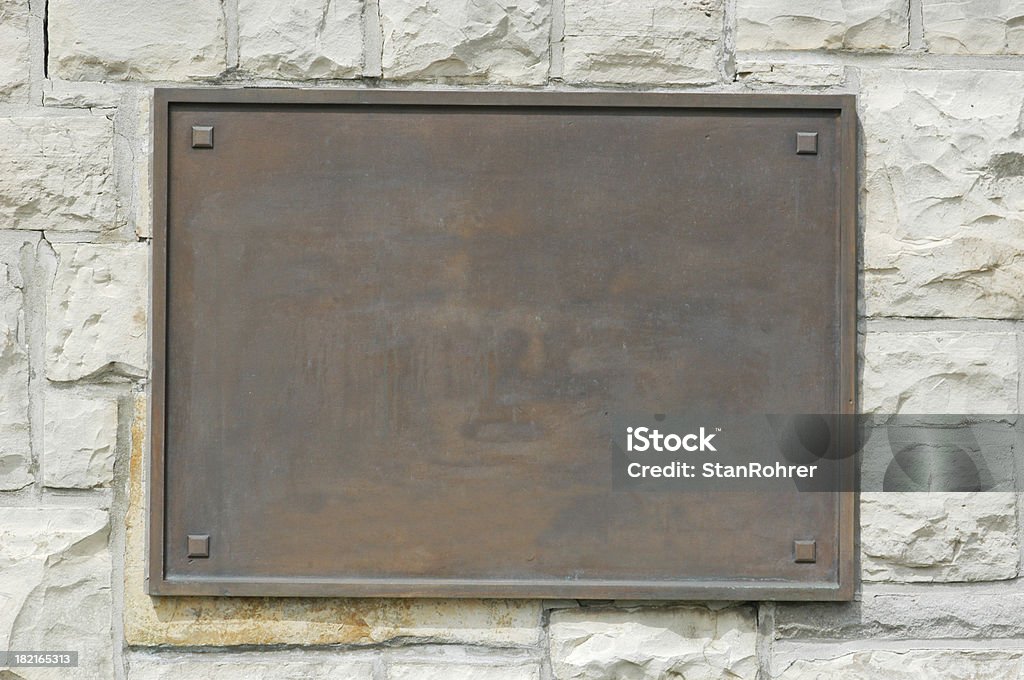 Bronze Memorial Plaque On Stone Wall Bronze plaque on stone wall. Add your own text or image. Clipping path included to isolate the sign from the wall. Award Plaque Stock Photo
