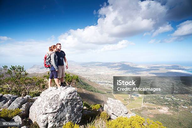 Couple Hiking Standing On A Large Rock Enjoying The View Stock Photo - Download Image Now