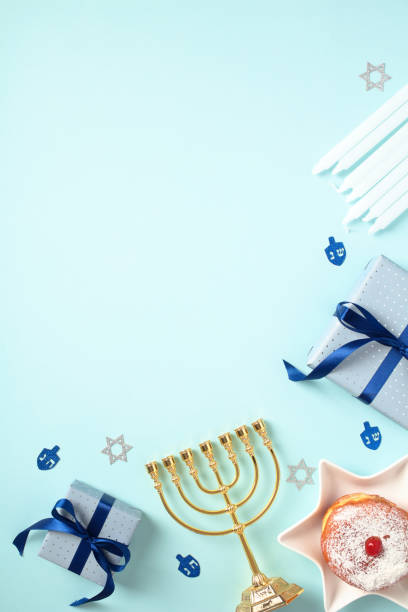 istock Hanukkah greeting card design. Flat lay composition with gift boxes, golden menorah, jelly doughnut, candles on blue background. 1821669160