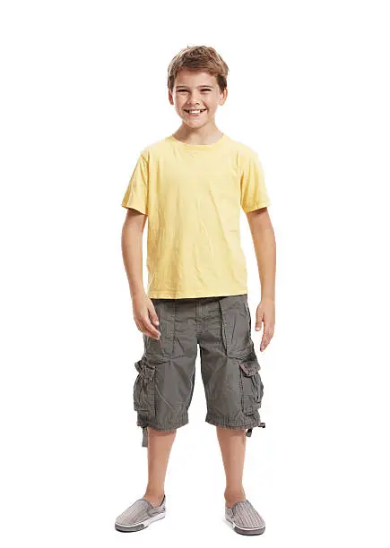"Full length portrait of a happy, little boy standing isolated on white background"