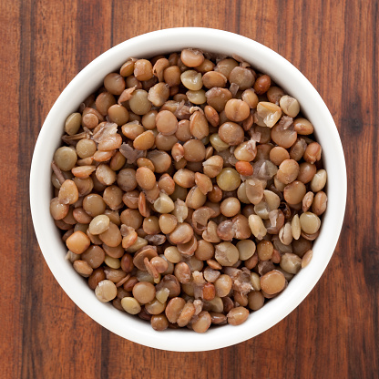 Top view of white bowl full of boiled lentils