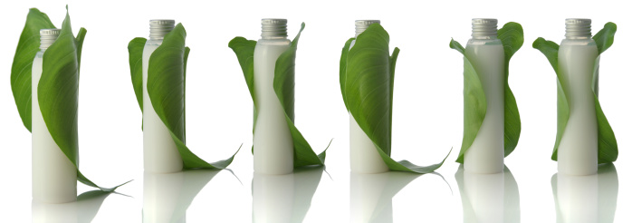 White bottles with a leaf wrapped around.Clipping path
