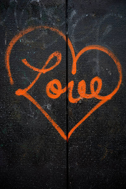Concept or conceptual painted red abstract heart shape love symbol, dirty wall background, metaphor to urban and romantic valentine, grungy style.