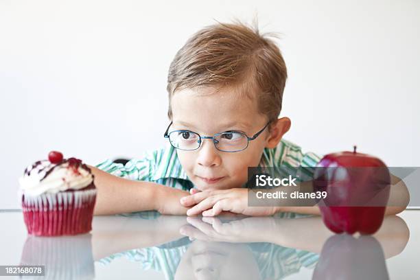 Rapaz Escolher Entre Um Bolinho E Apple - Fotografias de stock e mais imagens de Criança - Criança, Escolher, Alimentação Saudável