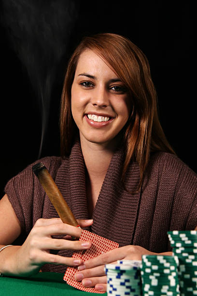 frau spielt poker mit zigarre - modelks stock-fotos und bilder