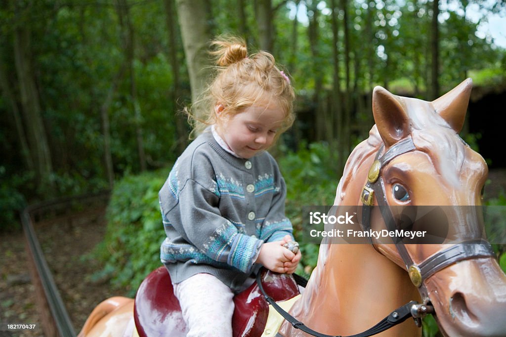 Dziewczyna na koniu w wesołym miasteczku - Zbiór zdjęć royalty-free (Atrakcja w wesołym miasteczku)