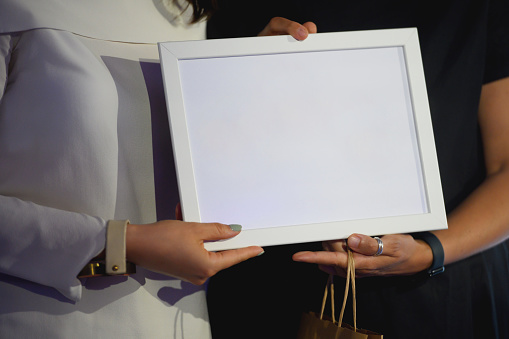 Female hands holding a plaque at an awards ceremony, copy space