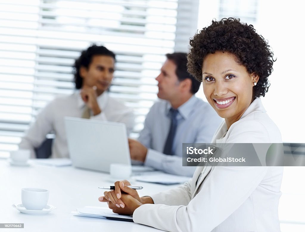 Деловая женщина улыбается с коллегами в фоновом режиме - Стоковые фото Красавица роялти-фри