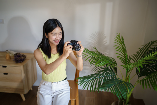Happy young Asian Woman photographer holding cameraÂ Creative female freelancer working freelance creative artist.